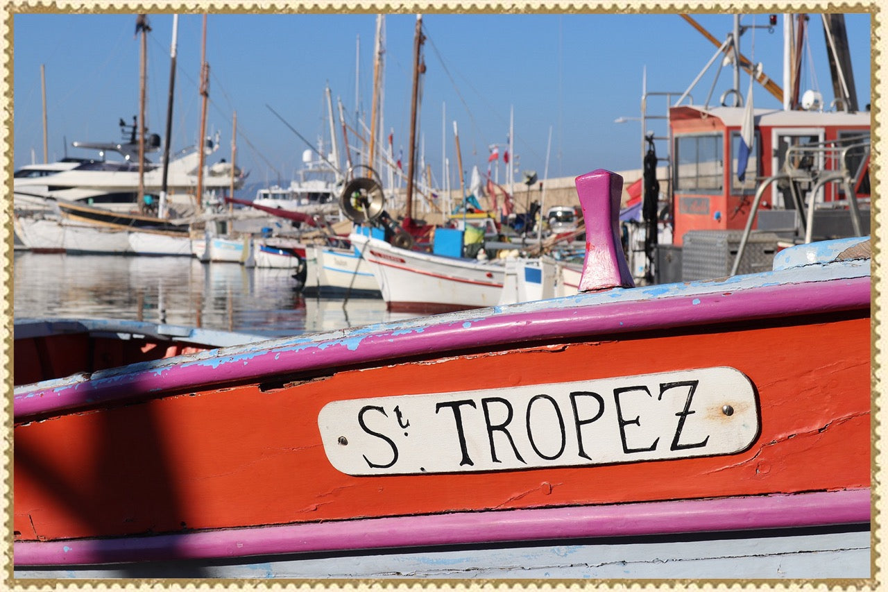 Colorful boat labeled “St. Tropez” at a marina.