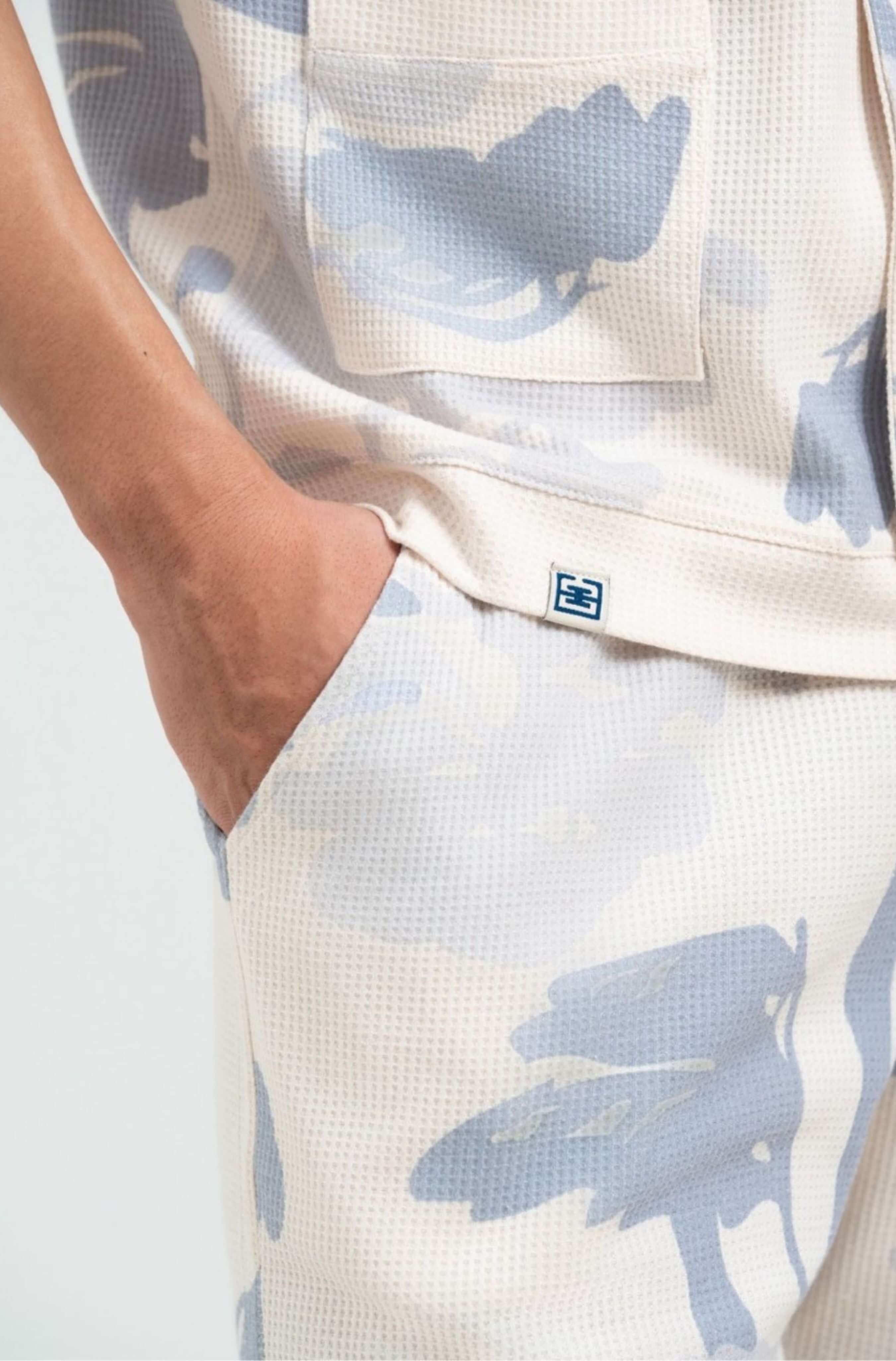 Small embroidered logo near hem – Pink Parasol men’s resort shirt