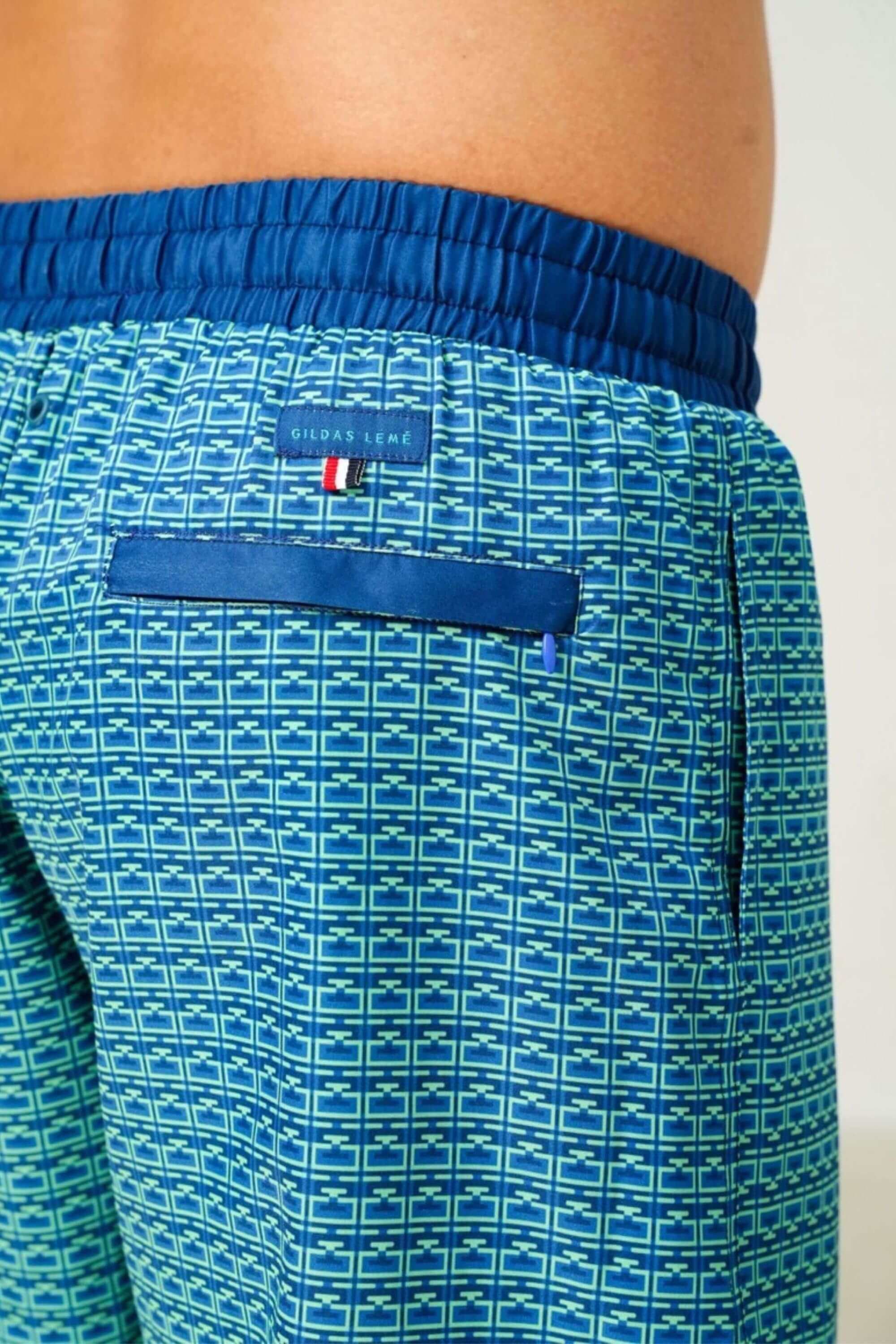 monogram edition swim trunk ocean green back pocket on model #color_ocean green